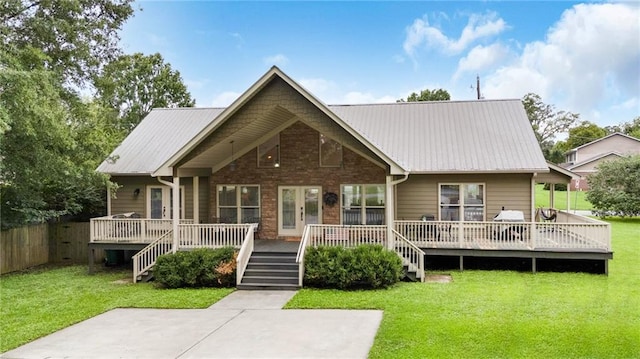 view of front of home featuring metal roof, fence, a front lawn, and a wooden deck