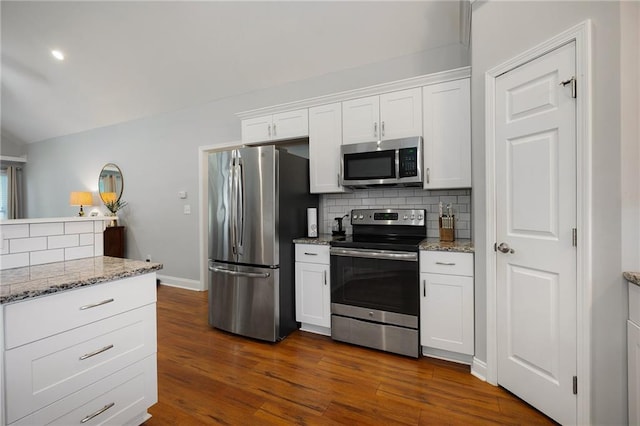 kitchen featuring white cabinets, light stone countertops, tasteful backsplash, and stainless steel appliances