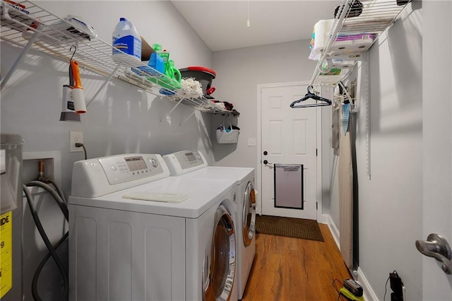 laundry room with laundry area, wood finished floors, and washer and dryer