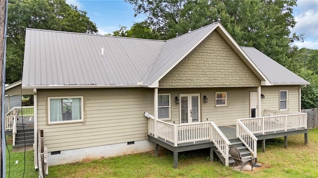 back of property with a wooden deck, a lawn, metal roof, crawl space, and french doors