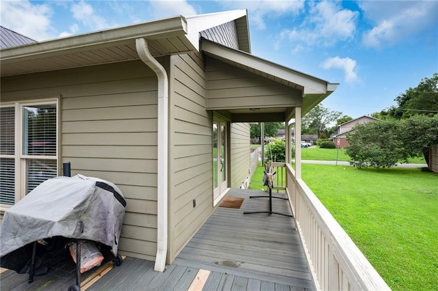 wooden deck featuring a grill and a lawn