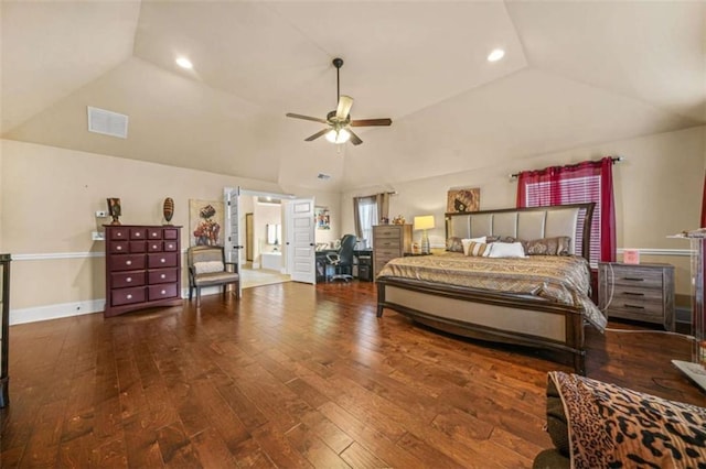 bedroom with vaulted ceiling, hardwood / wood-style floors, and a tray ceiling