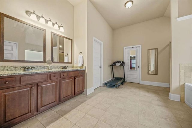 bathroom with vanity, tile patterned flooring, high vaulted ceiling, and a bathtub