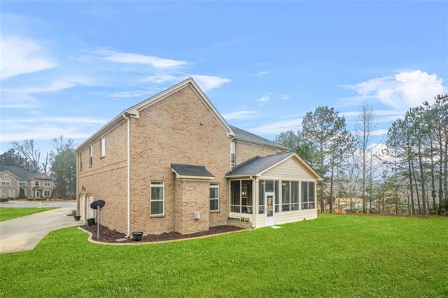 rear view of house with a sunroom and a yard