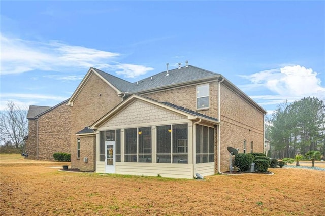 back of house with a yard and a sunroom