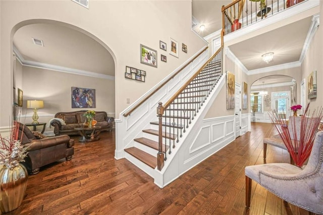 stairway with wood-type flooring and ornamental molding