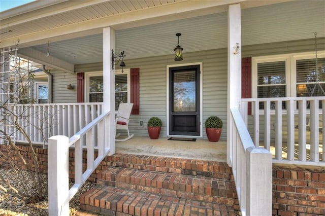 view of exterior entry featuring covered porch