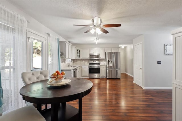 dining space featuring a textured ceiling, dark hardwood / wood-style floors, ceiling fan, and sink