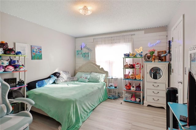 bedroom with a textured ceiling and light wood-type flooring