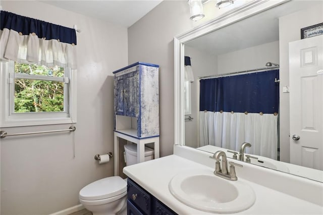 bathroom with curtained shower, vanity, and toilet