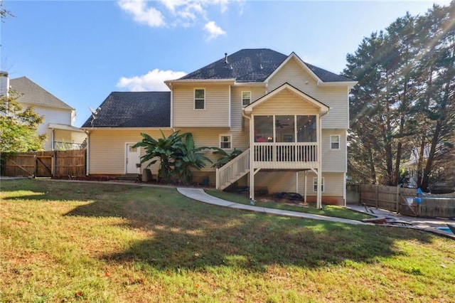 back of property with a lawn and a sunroom