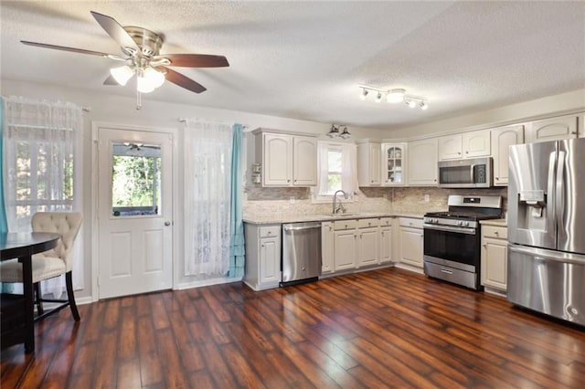 kitchen with dark hardwood / wood-style floors, sink, white cabinets, stainless steel appliances, and ceiling fan