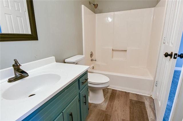 bathroom with shower / washtub combination, wood finished floors, toilet, and vanity