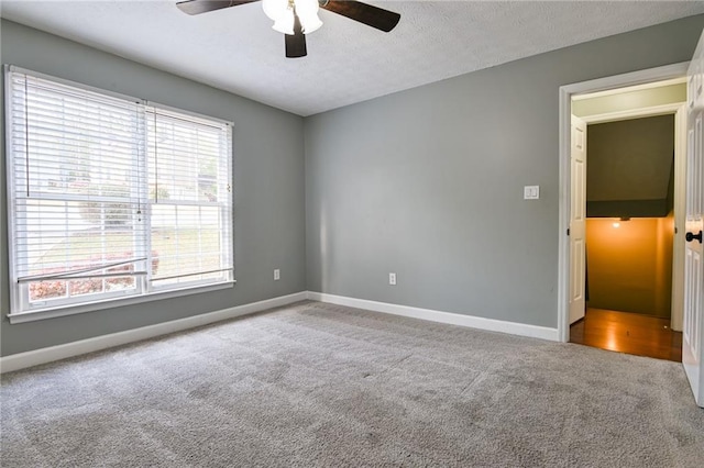 spare room featuring carpet flooring, a ceiling fan, baseboards, and a textured ceiling