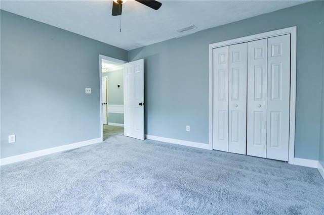 unfurnished bedroom featuring carpet flooring, baseboards, visible vents, a ceiling fan, and a closet