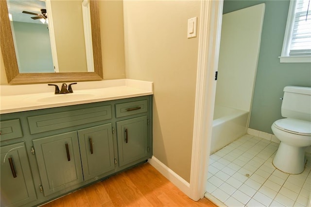 full bathroom with a bathtub, baseboards, ceiling fan, toilet, and vanity