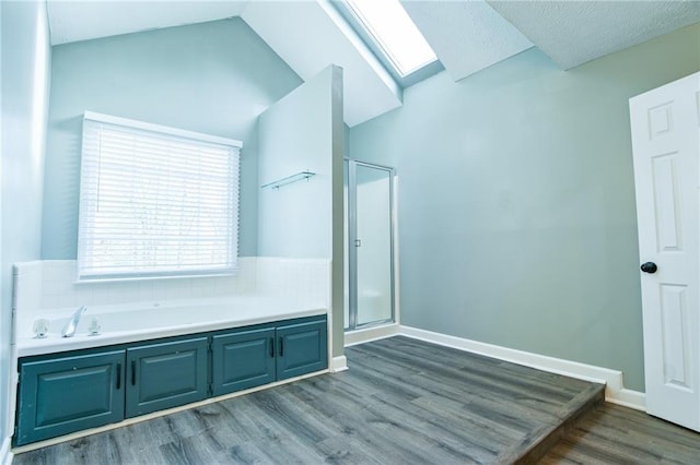 bathroom featuring a bath, lofted ceiling, wood finished floors, and a stall shower