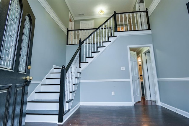 staircase with a high ceiling, wood finished floors, and ornamental molding