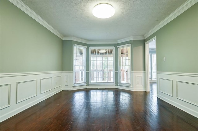 spare room with a textured ceiling, wood finished floors, and crown molding