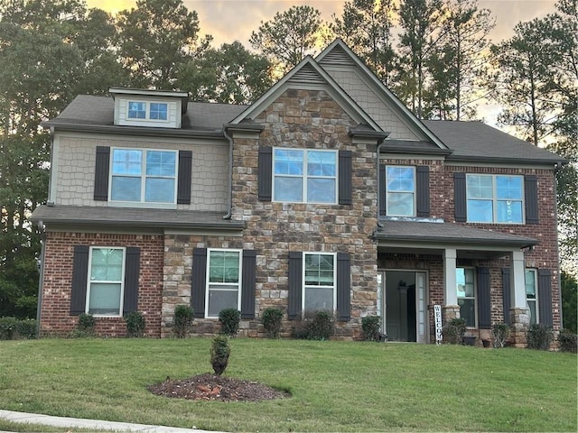 craftsman inspired home featuring stone siding and a lawn