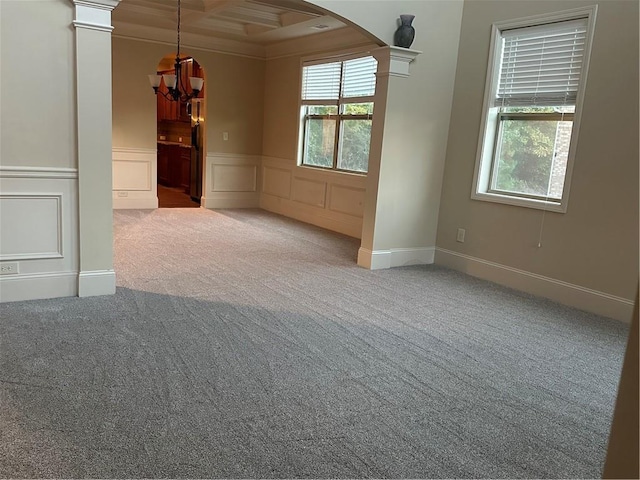 carpeted empty room featuring ornate columns