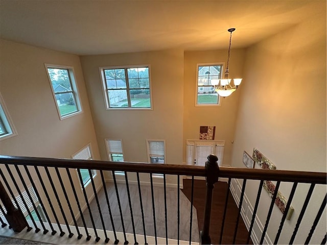 staircase with an inviting chandelier and hardwood / wood-style floors