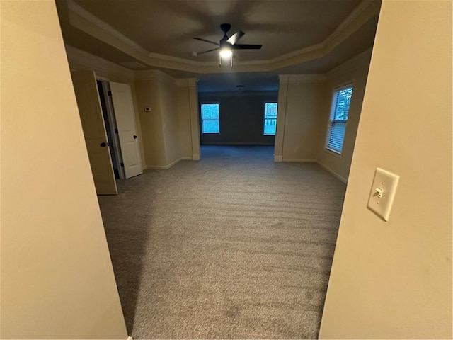 carpeted empty room featuring baseboards, crown molding, a ceiling fan, and a raised ceiling