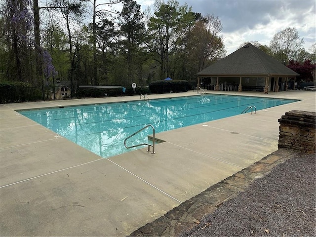community pool featuring fence and a patio area