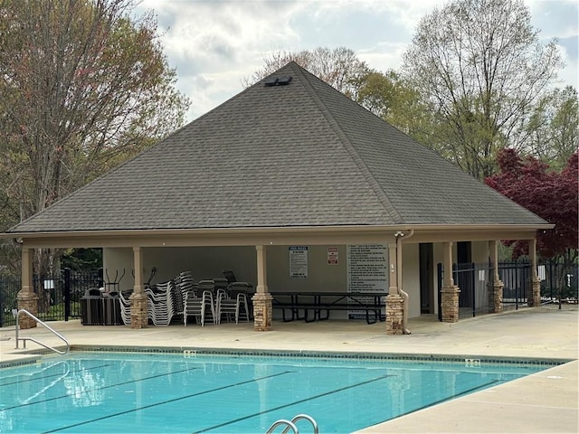 pool with a patio and fence