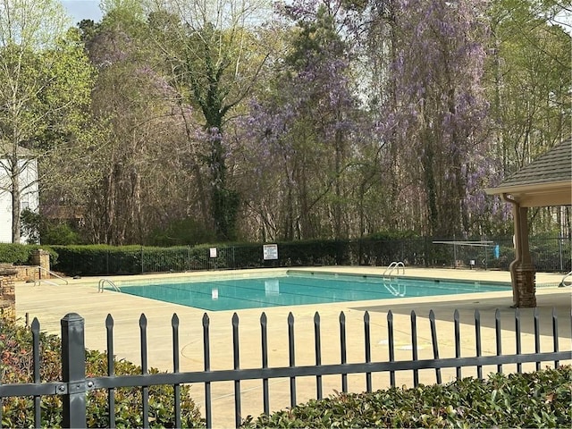 pool featuring fence and a patio area