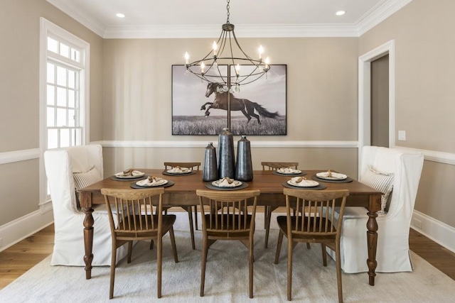 dining room with crown molding, hardwood / wood-style floors, and a notable chandelier