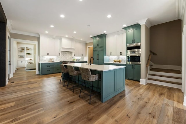 kitchen featuring ornamental molding, sink, backsplash, and light hardwood / wood-style floors