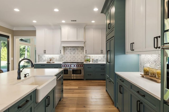 kitchen with light wood-type flooring, white cabinetry, sink, and stainless steel appliances