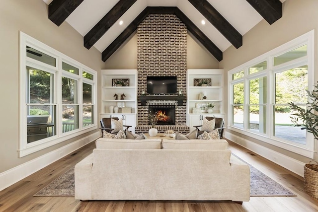 living room featuring wood-type flooring, plenty of natural light, and high vaulted ceiling