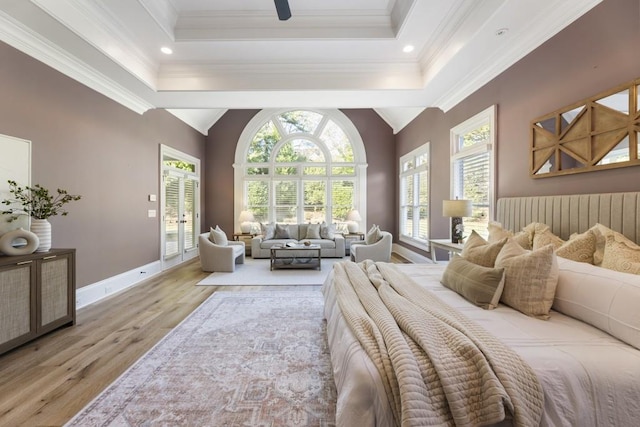 bedroom with access to outside, light hardwood / wood-style floors, crown molding, and a raised ceiling