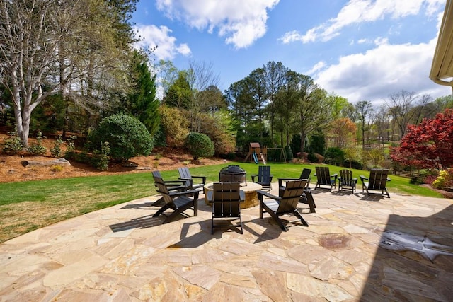 view of patio featuring a playground and an outdoor fire pit