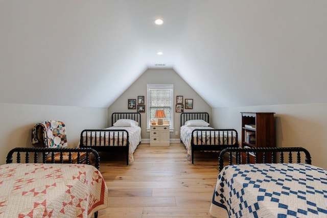 bedroom featuring lofted ceiling and light wood-type flooring