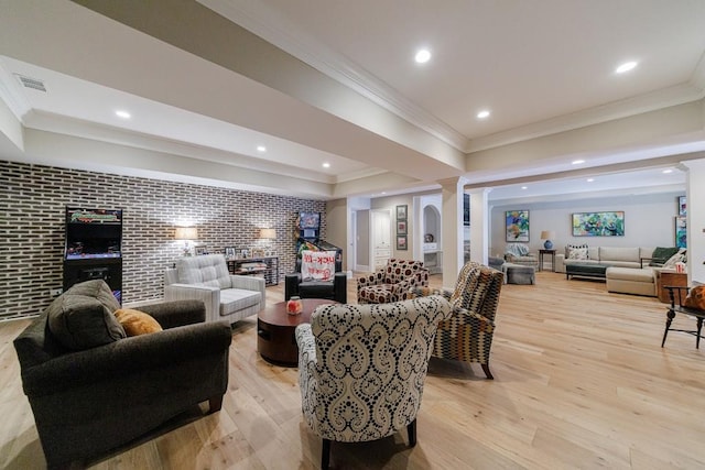 living room featuring ornamental molding, decorative columns, and light hardwood / wood-style floors