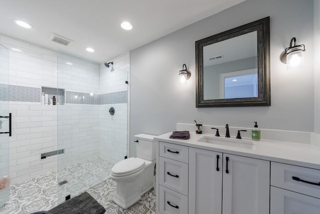 bathroom with vanity, a shower with shower door, toilet, and tile patterned floors