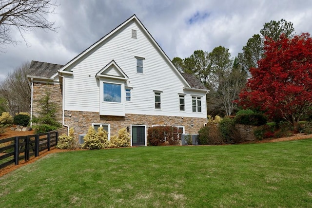 back of property with cooling unit and a yard