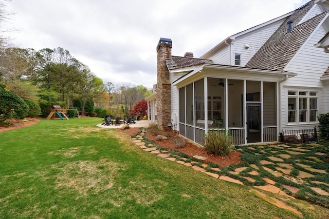 view of yard featuring a sunroom and a playground