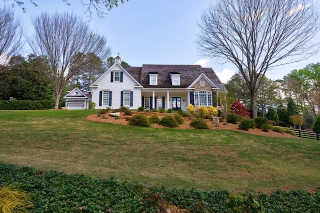 view of front of property featuring a garage, a porch, and a front yard