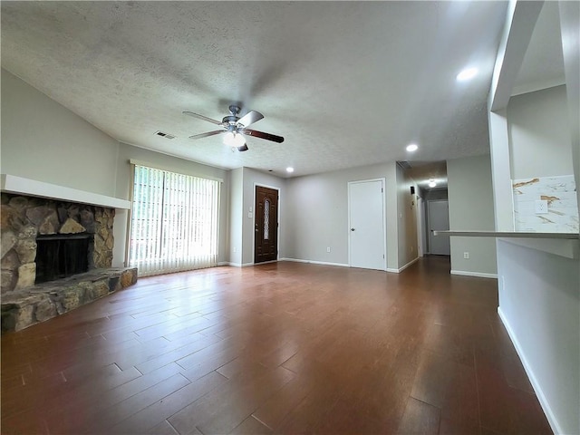 2913 Jordan Forest Trl, Lawrenceville, GA 30044 - unfurnished living room with ceiling fan, dark wood-style floors, a stone fireplace, a textured ceiling, and recessed lighting