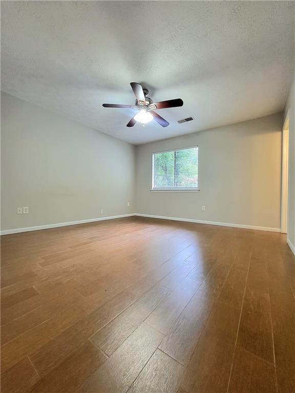 2913 Jordan Forest Trl, Lawrenceville, GA 30044 - empty room featuring wood finished floors, a ceiling fan, and a textured ceiling