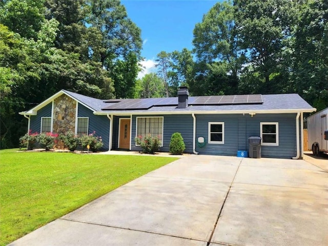 2913 Jordan Forest Trl, Lawrenceville, GA 30044 - view of front of home with a front yard, solar panels, concrete driveway, and a chimney