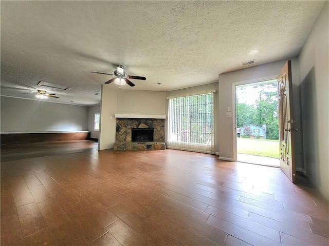 2913 Jordan Forest Trl, Lawrenceville, GA 30044 - unfurnished living room featuring ceiling fan, a textured ceiling, wood finished floors, and a fireplace