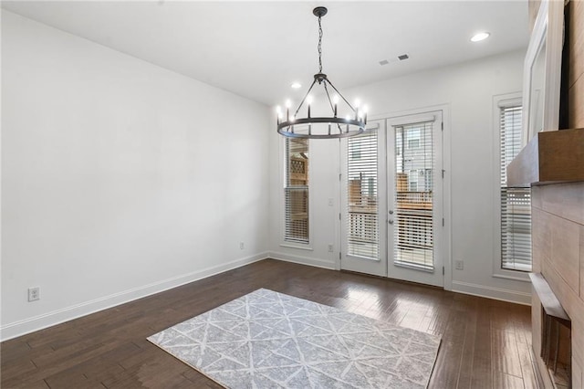 entryway with dark hardwood / wood-style flooring and a chandelier