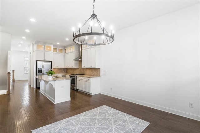 kitchen with stainless steel appliances, a center island, hanging light fixtures, and white cabinets