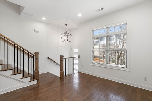 entrance foyer featuring an inviting chandelier and dark hardwood / wood-style floors