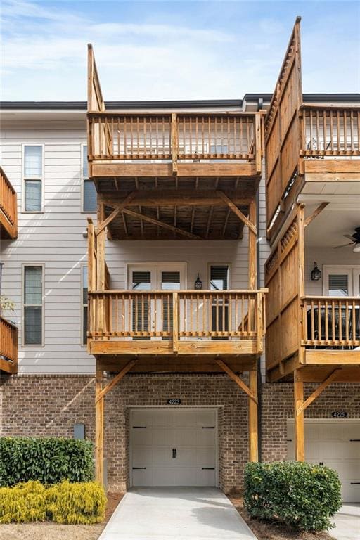 rear view of property with a garage and a balcony